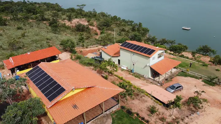 Vista aérea de rancho à beira do lago em São Gonçalo do Abaeté com sistema solar híbrido em dois telhados